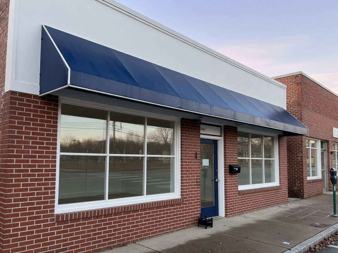 Main-street storefront with a navy awning and white trim